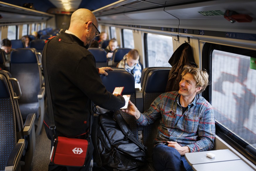 Le controleur CFF Nicolas Constantin verifie les titres de transport des voyageurs dans un train InterCity lors de la premiere journee de la levee des mesures COVID concernant le port du masque obliga ...