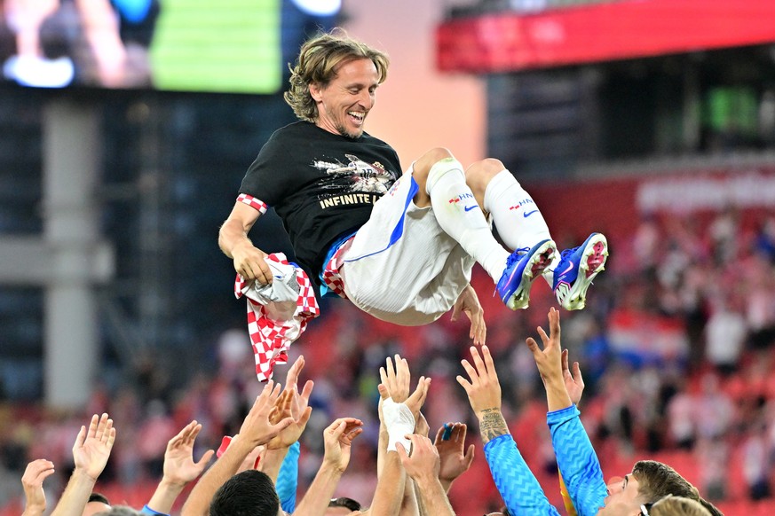 epaselect epa13059866 Luka Modric of Croatia (C) is thrown in the air as his teammates wear shirts celebrating Modric's 200th game for Croatia after winning the FIFA World Cup 2026 group stage ma ...