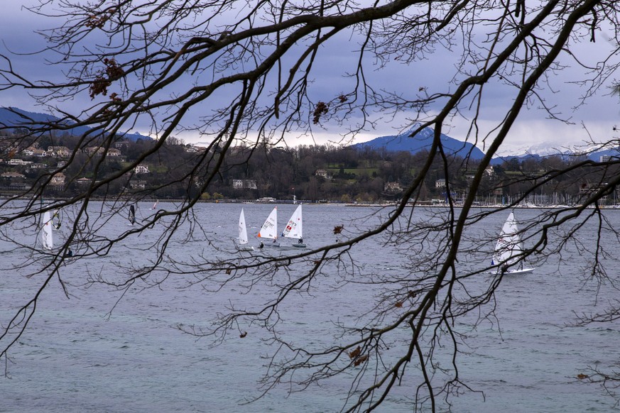 Des bateaux &quot;Laser&quot; et des planches a voile naviguent par vent fort sur le lac Leman , ce samedi 13 mars 2021 a Geneve. (KEYSTONE/Salvatore Di Nolfi)