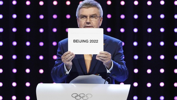 FILE - President of the International Olympic Committee (IOC) Thomas Bach opens the envelope announcing that Beijing has won the bid to host the 2022 Winter Olympic Games at the 128th International Ol ...
