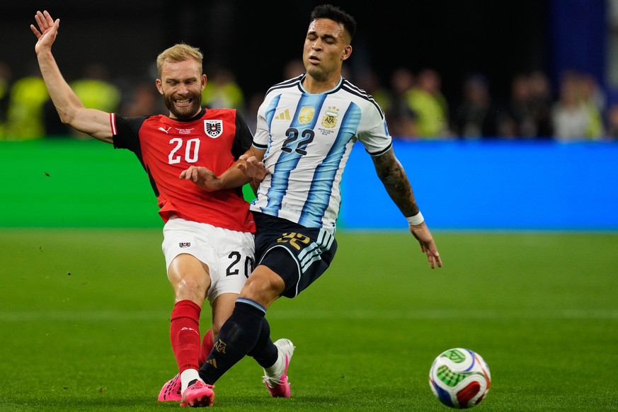 Argentina's Lautaro Martinez (22) and Austria's Konrad Laimer battle for the ball during the World Cup Group J soccer match in Arlington, Texas, near Dallas, Monday, June 22, 2026. (AP Photo ...