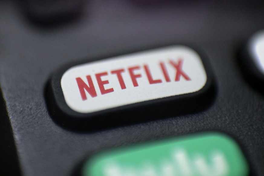 FILE - A logo for Netflix is seen on a remote control in Portland, Ore., on Aug. 13, 2020. Netflix will unveil the first version of its video streaming service with ads in November 2022, giving cost-c ...