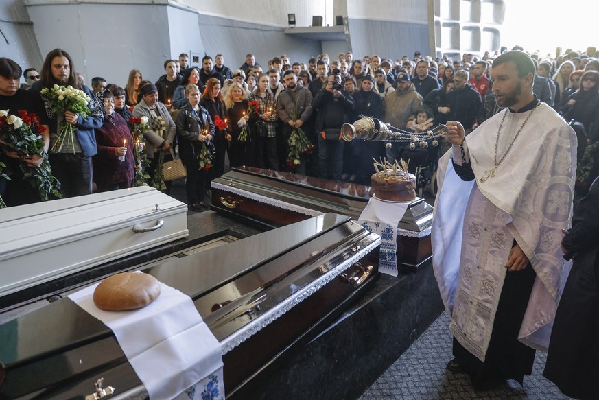 epa12060404 Relatives and friends of late Danylo Khudia (17) and his parents, Oleg and Victoria, attend their funeral at the Baykove cemetery in Kyiv, Ukraine, 28 April 2025, amid the Russian invasion ...