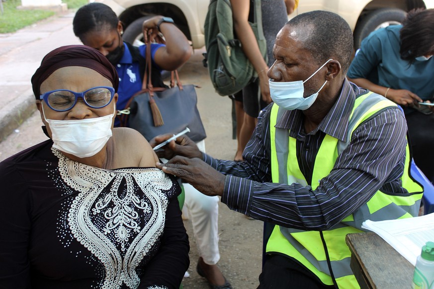 FILE - A woman receives a coronavirus vaccine in Abuja, Nigeria, Monday, Nov 29, 2021. A pandemic-weary world faces weeks of confusing uncertainty as countries restrict travel and take other steps to  ...