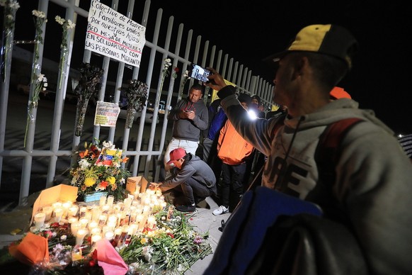 epa10548326 A group of migrants and relatives of people that were killed in a fire hold a vigil in memory of the victims in front of the National Institute of Migration (INM) in Ciudad Juarez, Chihuah ...
