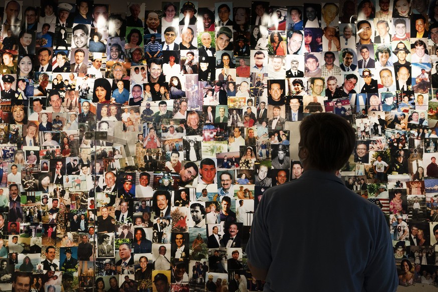 Désirée Bouchat, a survivor of the 9/11 attacks on the World Trade Center, looks at photos of those who perished, in a display at the 9/11 Tribute Museum, Friday, Aug. 6, 2021, in New York. While Sept ...