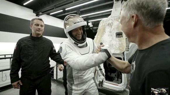 In this image made from SpaceX video, tech entrepreneur Jared Isaacman, center, greets as he gets out of its capsule upon his return with his crew after the capsule landed in the Gulf of Mexico near F ...