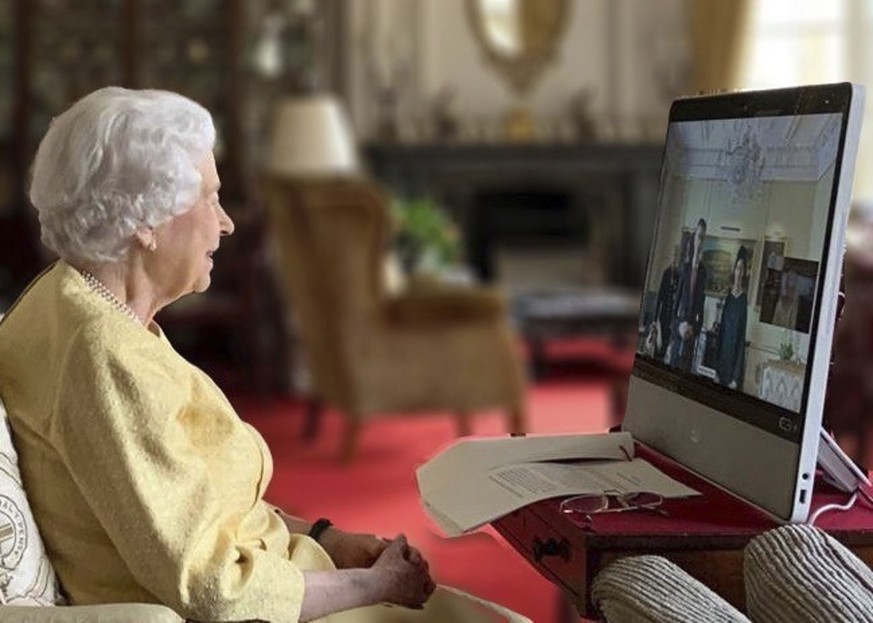 In this handout photo provided by Buckingham Palace, Britain's Queen Elizabeth II holds a virtual audience via video link with the Ambassador from the Swiss Confederation, Markus Leitner, accompa ...