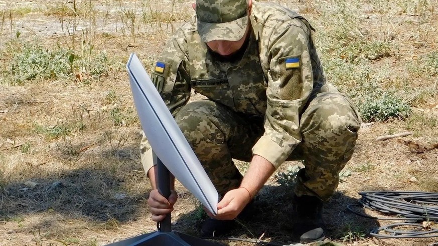 Ein ukrainischer Soldat beim Einrichten eines Starlink-Terminals.