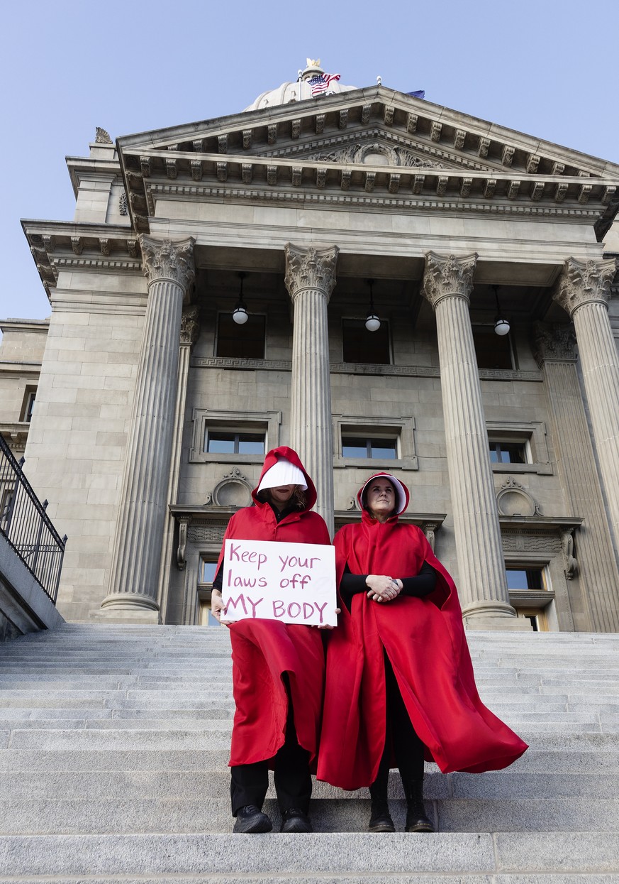 FILE - Two people stand on the steps of the Idaho State Capitol Building, during a protest, in downtown Boise, Idaho on May 3, 2022. The U.S. Supreme Court ruling overturning Roe v. Wade has legal adv ...