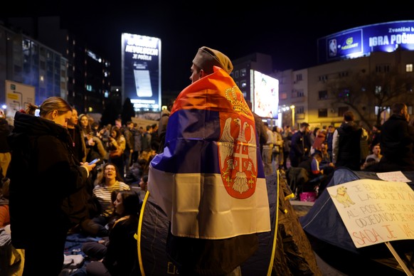 epa11857222 A protester draped in a Serbian flag takes part in the blockade of the &#039;Autokomanda&#039; intersection in Belgrade, Serbia, 27 January 2025. University students staged a protest, dema ...