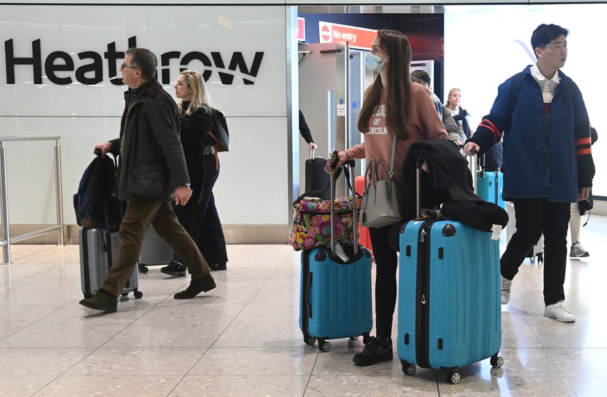 epa10390387 Travellers arrive at Heathrow Airport in London, Britain, 05 December 2023. From 05 January 2023, people traveling from China to the UK will need to show a negative Covid-19 test taken no  ...