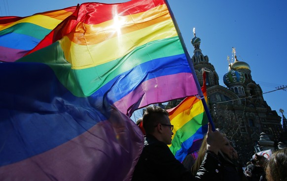 FILE - Gay rights activists carry rainbow flags as they march during a May Day rally in St. Petersburg, Russia, Wednesday, May 1, 2013. Russia passed a law in 2013 that bans the depiction of homosexua ...