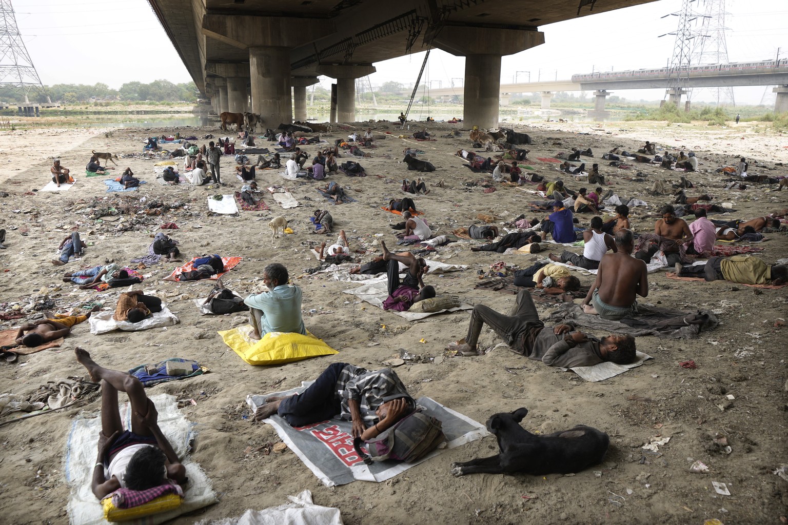 Homeless people sleep in the shade of an over-bridge to beat the heat wave in New Delhi, Friday, May 20, 2022. The intense heat wave sweeping through South Asia was made more likely due to climate cha ...