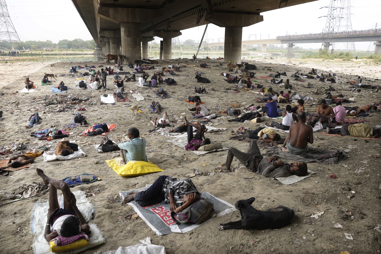 Homeless people sleep in the shade of an over-bridge to beat the heat wave in New Delhi, Friday, May 20, 2022. The intense heat wave sweeping through South Asia was made more likely due to climate cha ...