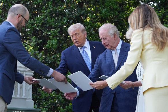 President Donald Trump and first lady Melania Trump along with Britain's King Charles III and Queen Camilla look at the White House bee hive on the South Lawn of the White House, Monday, April 27 ...