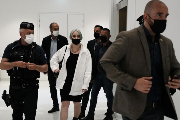 The teenager identifying herself online as Mila, center right, leaves the courtroom Monday, June 21, 2021 in Paris. Thirteen people went on trial in Paris accused of cyberbullying or death threats aga ...