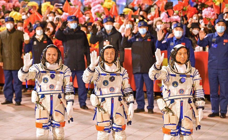 epa10336541 Taikonauts Fei Junlong (R), Deng Qingming (C), and Zhang Lu of the Shenzhou-15 manned space mission wave during a see-off ceremony at the Jiuquan Satellite Launch Center in Jiuquan, China, ...