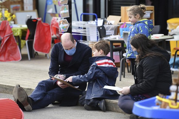 Britain&#039;s Prince William plays with a child in the playground during a visit with Kate, Duchess of Cambridge to School21, a school in east London, Thursday March 11, 2021. (Justin Tallis/Pool via ...