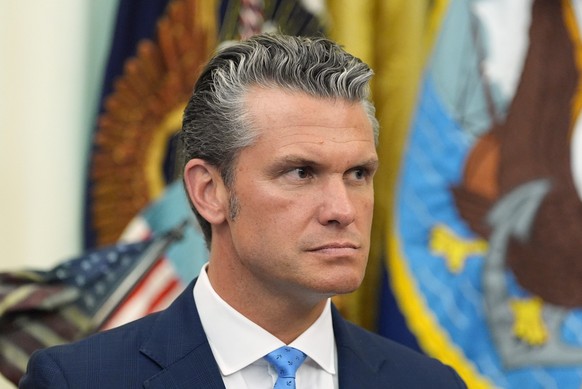 Defense Secretary Pete Hegseth listens as President Donald Trump speaks during a meeting about military families, in the Oval Office of the White House, Monday, Aug. 3, 2026, in Washington. (AP Photo/ ...