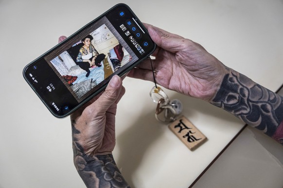 In this photograph taken on September 28, 2025, retired yakuza Mako Nishimura shows a picture of her younger self when she was a part of the underworld, during an interview with AFP at her residence i ...