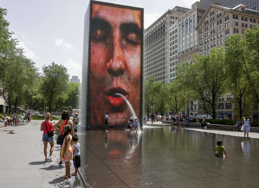 epa10015228 People seek relief from a dangerous heat wave at the Crown Fountain and wading pool in Chicago, Illinois, USA, 15 June 2022. Heat warnings and advisories have been issued that affect more  ...