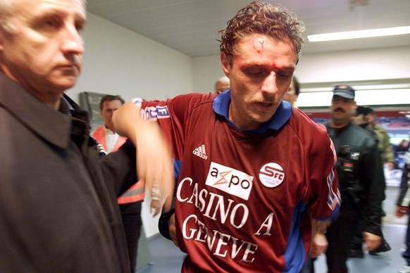 Le Servettien Sebastien Fournier, droite, part en direction des vestiaires devant le directeur sportif du FC Servette, Patrick Trotignon, gauche, apres avoir ete aggresse au visage par le joueur de fo ...
