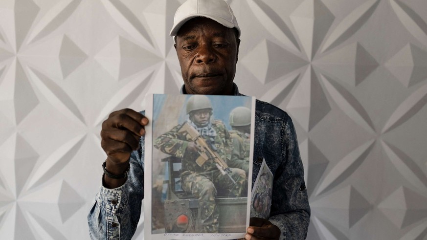 Charles Ojiambo Mutoka, 72 ans, pose avec les portraits de son fils Oscar, dont il a appris la mort en août, lors d'une conférence de presse à Nairobi, le 27 janvier 2026.