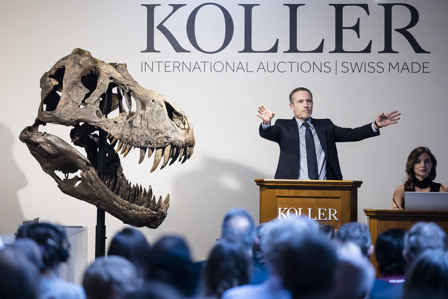 Cyril Koller, PDG de la maison de vente aux enchères Koller, fait un geste à côté de la tête du squelette d'un Tyrannosaurus rex nommé Trinity, lors d'une vente aux enchères de la maison de vente aux  ...