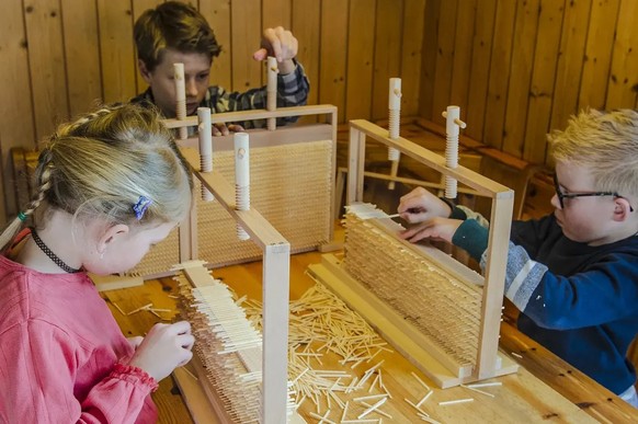 Insertion des tiges de bois dans des cadres (reproduits). Après l’interdiction du travail en usine pour les enfants, cette étape fut réalisée à domicile.