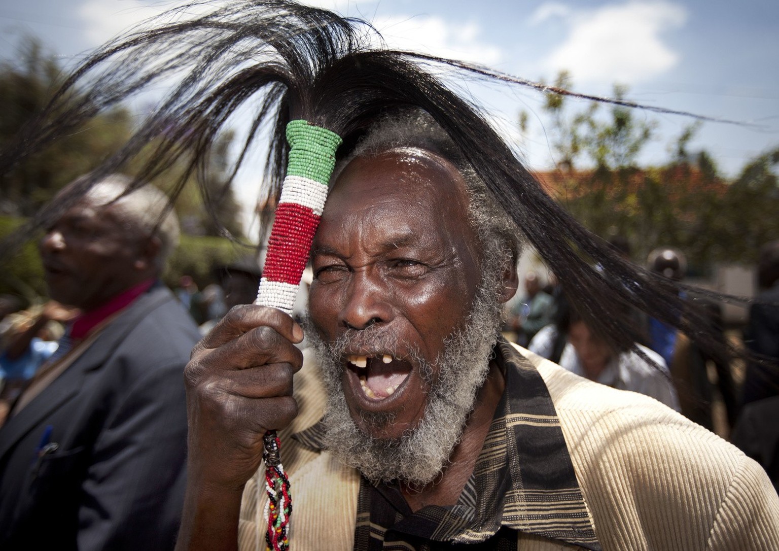 Lawrence Mathenge, representative of the Mau Mau War Veterans Association, celebrates the announcement of a legal decision in Britain&#039;s High Court concerning Mau Mau veterans, while holding a cer ...