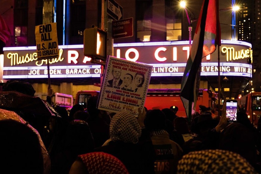 NEW YORK, NEW YORK - MARCH 28: Pro-Palestinian demonstrators hold up a sign outside Radio City Music Hall during President Joe Biden&#039;s fundraiser on March 28, 2024 in New York City. Biden will be ...