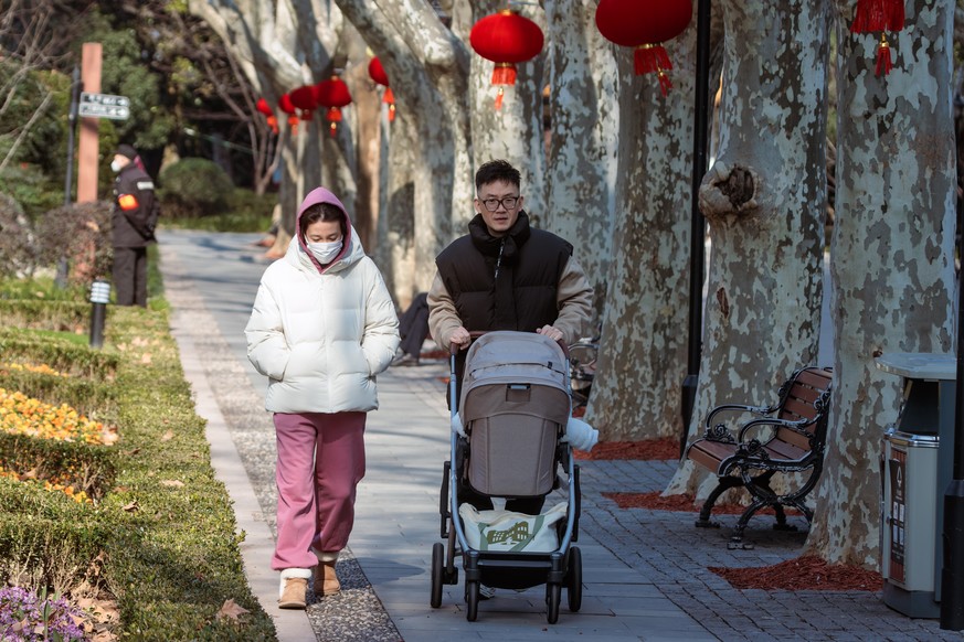 epa10410133 A family walk in the park, in Shanghai, China, 17 January 2023. China?s population dropped from 1.41260 in 2021 to 1.41175 billion people in 2022. It is the first decline since 1961, accor ...