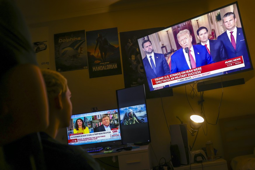 epa12190353 Young people watch US President Donald Trump address the nation following the U.S. attack on Iran&#039;s nuclear sites, in Miami, Florida, USA, 22 June 2025. President Trump stated that th ...