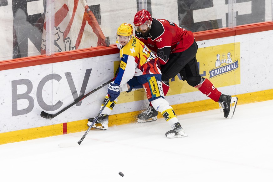 PostFinance Top Scorer Petteri Puhakka (EHCK), gauche, lutte pour le puck avec Fabian Heldner (LHC), droite, lors du match du championnat suisse de hockey sur glace de National League entre Lausanne H ...