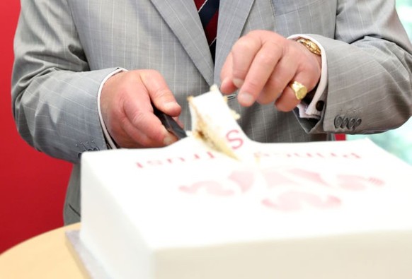 NANTGARW, WALES - JULY 01: Prince Charles, Prince of Wales cuts a cake as he celebrates 50 years since he was invested as the Prince of Wales during a visit to a Prince’s Trust call centre to meet sta ...