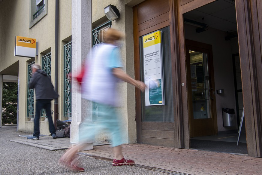 Une personne rentre dans la poste pour effectue une operation au guichet, avant un rassemblement de protestation contre la fermeture de la poste de Croix-de-Rozon et ainsi montrer leur indignation et  ...