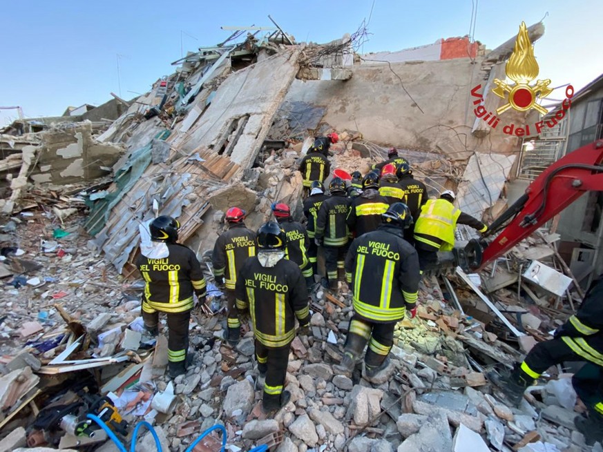 epa09639814 A handout photo made available by Vigili del Fuoco shows rescue teams at the scene of a blast caused by a gas leak in Ravanusa, Sicily, Italy, 13 December 2021. Firefighters found a fourth ...