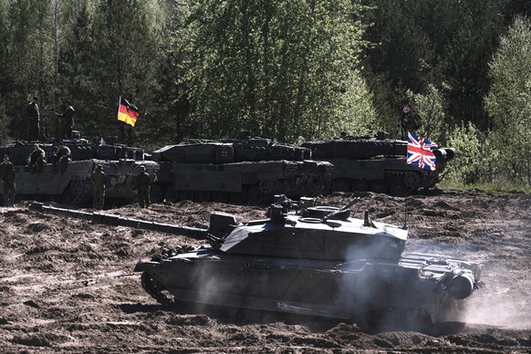 epa11316790 German servicemen with their main battle tank Leopard 2 A7 (L) and British servicemen with their main battle tank Challenger 2 participate in the Canadian Army Trophy (CAT) tank competitio ...