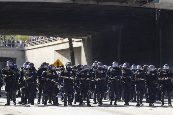 KEYPIX - epa12165710 Police officers move to clear activists protesting immigration raids from the road near the Edward R. Roybal Federal Building in Los Angeles, California, USA, 08 June 2025. US Pre ...