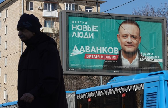 epa11218428 A man walks in front of a campaign poster of presidential candidate, the &#039;New People&#039; political party Vladislav Davankov, in Moscow, Russia, 13 March 2024. The Russian presidenti ...