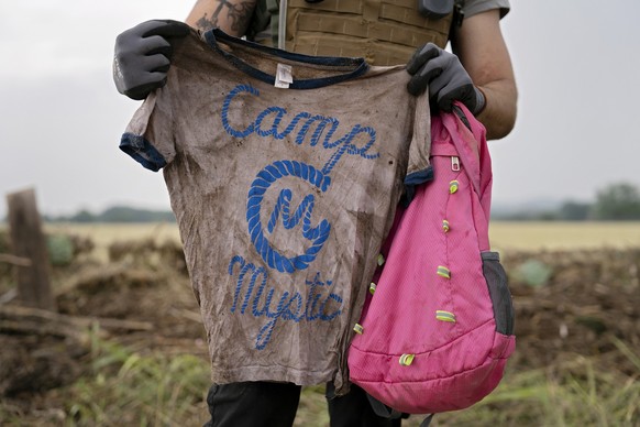 COMFORT, TEXAS - JULY 6: A search and rescue volunteer holds a T-shirt and backpack with the words Camp Mystic on them in Comfort, Texas on July 6, 2025. The volunteer found the belongings yesterday a ...