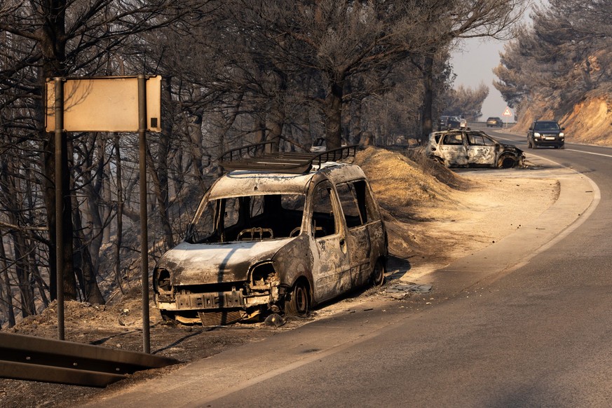 epa13168747 Burnt-out cars are seen on a road after a wildfire near the town of Omis, Croatia, 14 August 2026. Wildfires across the region have forced the evacuation of around 2,000 residents, with at ...
