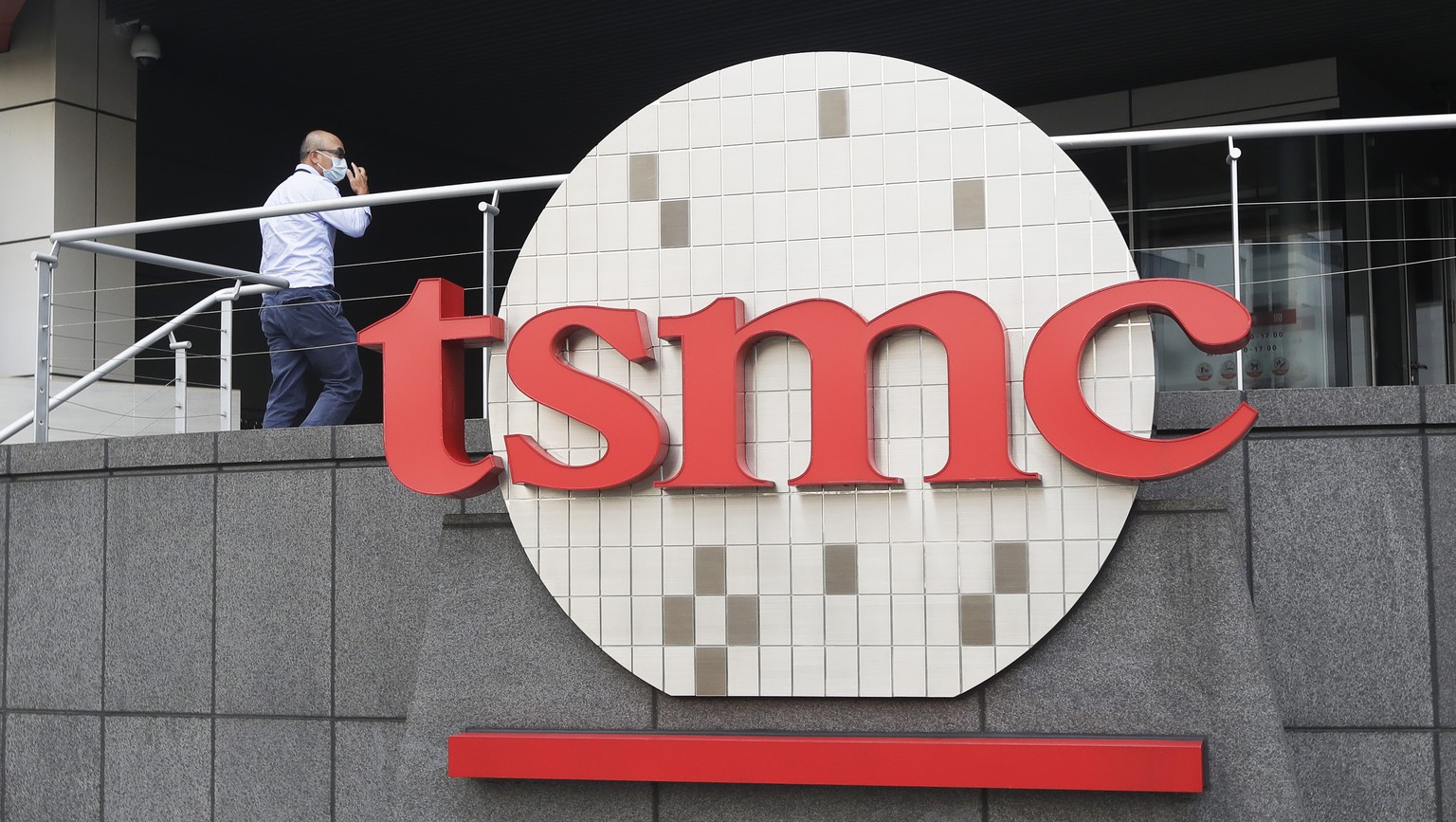FILE - A person walks into the Taiwan Semiconductor Manufacturing Co., Ltd. (TSMC) headquarters in Hsinchu, Taiwan, on Oct. 20, 2021. Taiwan Semiconductor Manufacturing Co., the biggest contract manuf ...