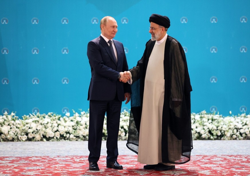 epa10080531 Russian President Vladimir Putin (L) shakes hands with Iranian President Ebrahim Raisi (R) during a trilateral summit on Syria in Tehran, Iran, 19 July 2022. The tripartite summit on Syria ...