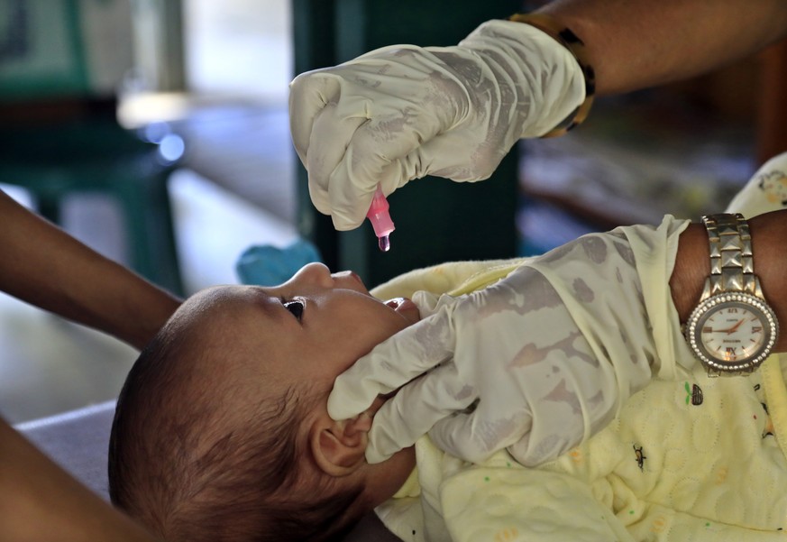epa09505029 A healthcare worker administers drops of Polio vaccine to an infant amid the COVID-19 pandemic at a community healthcare center in Dili, East Timor, also known as Timor Leste, 04 October 2 ...