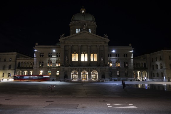 Ein Bus faehrt spaetabends ueber den Bundesplatz am dunklen Bundeshaus vorbei, am Rand der Herbstsession der Eidgenoessischen Raete, am Mittwoch, 21. September 2022 in Bern. Die Verwaltungsdelegation  ...