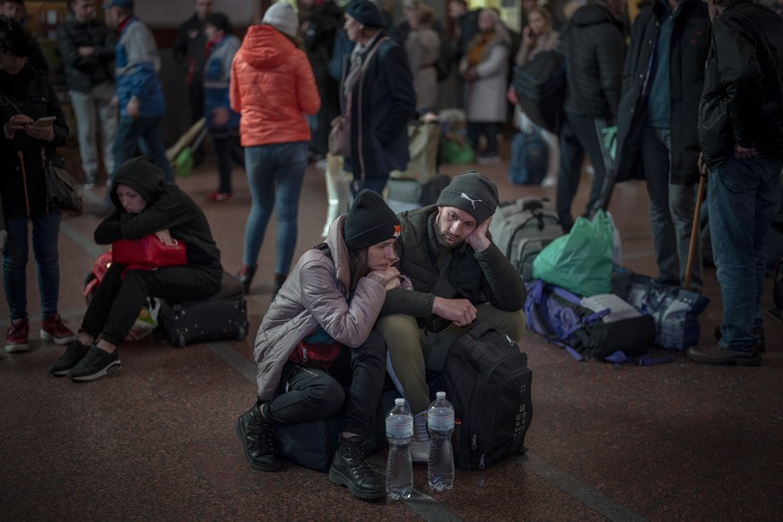 Ukrainians wait for a train to leave their country at the train station in Lviv, western Ukraine, Friday, April 15, 2022. (AP Photo/Emilio Morenatti)