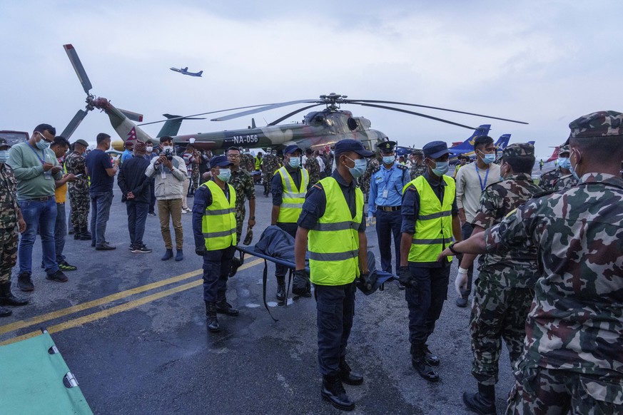 Nepalese policemen shift the dead body of a plane crash victim to an ambulance at an airport in Kathmandu, Nepal, Monday, May 30, 2022. Rescuers searching a mountainside in Nepal on Monday recovered t ...