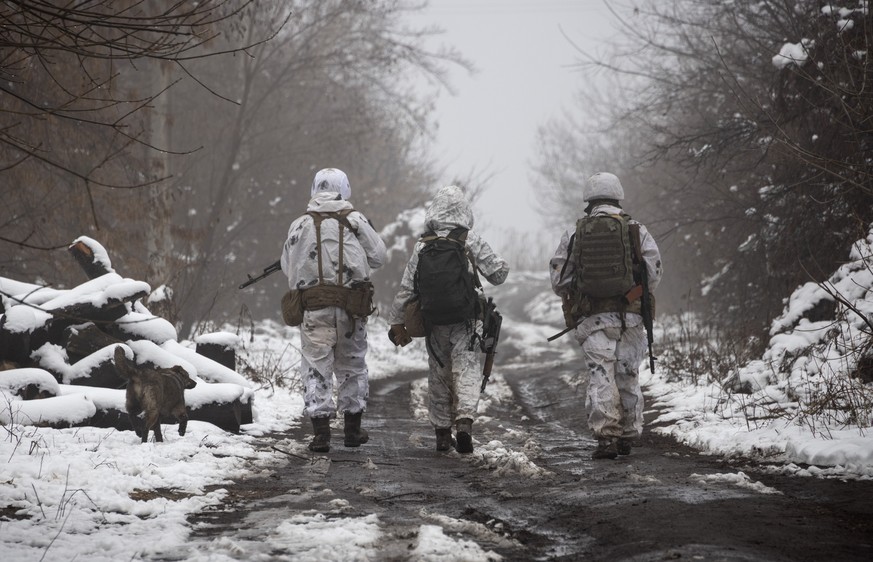 Ukrainian soldiers walks at the line of separation from pro-Russian rebels near Katerinivka, Donetsk region, Ukraine, Tuesday, Dec 7, 2021. Ukrainian authorities on Tuesday charged that Russia is send ...